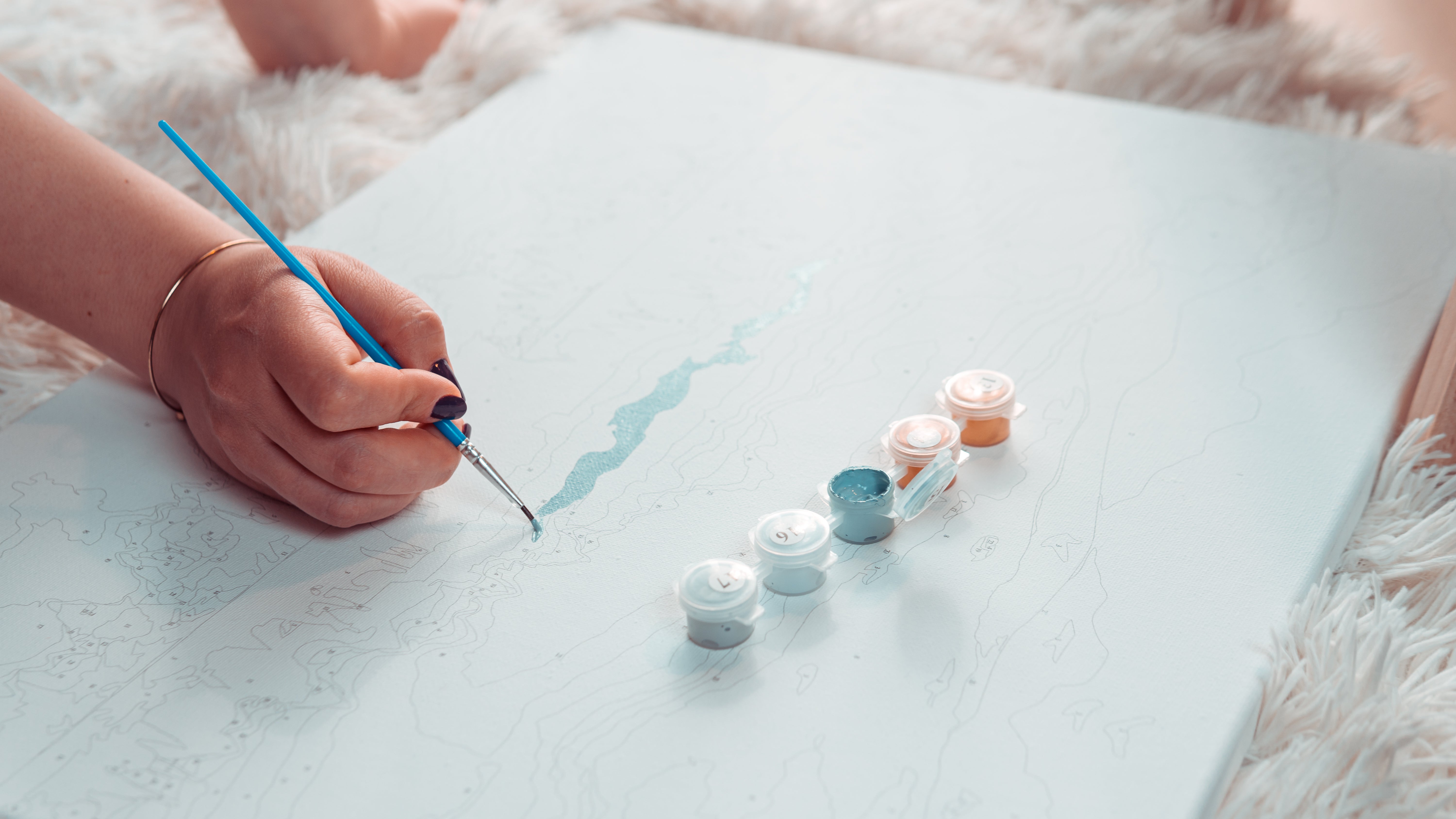 Peinture par numéros en cours de réalisation posée sur une table avec un pinceau fin