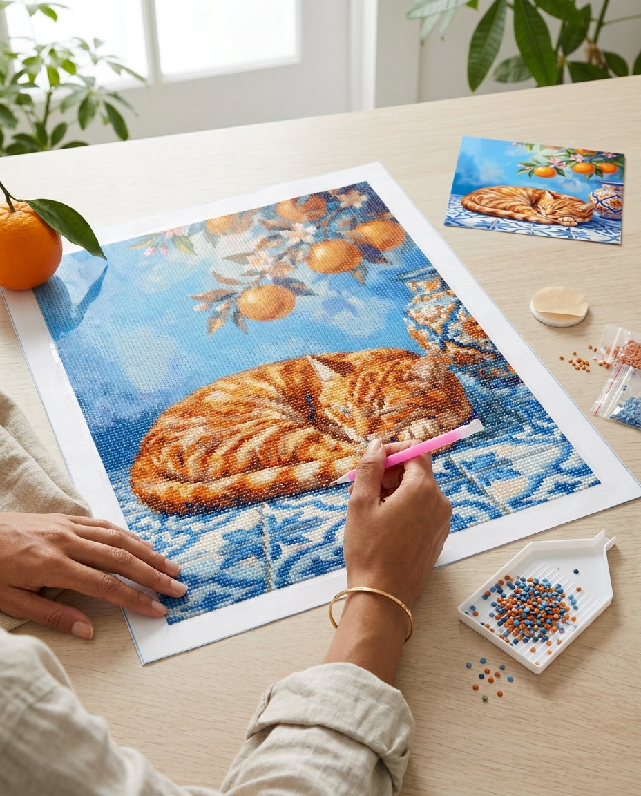 Diamond Painting Chat Roux aux Oranges en cours de réalisation, vue du dessus du plan de travail